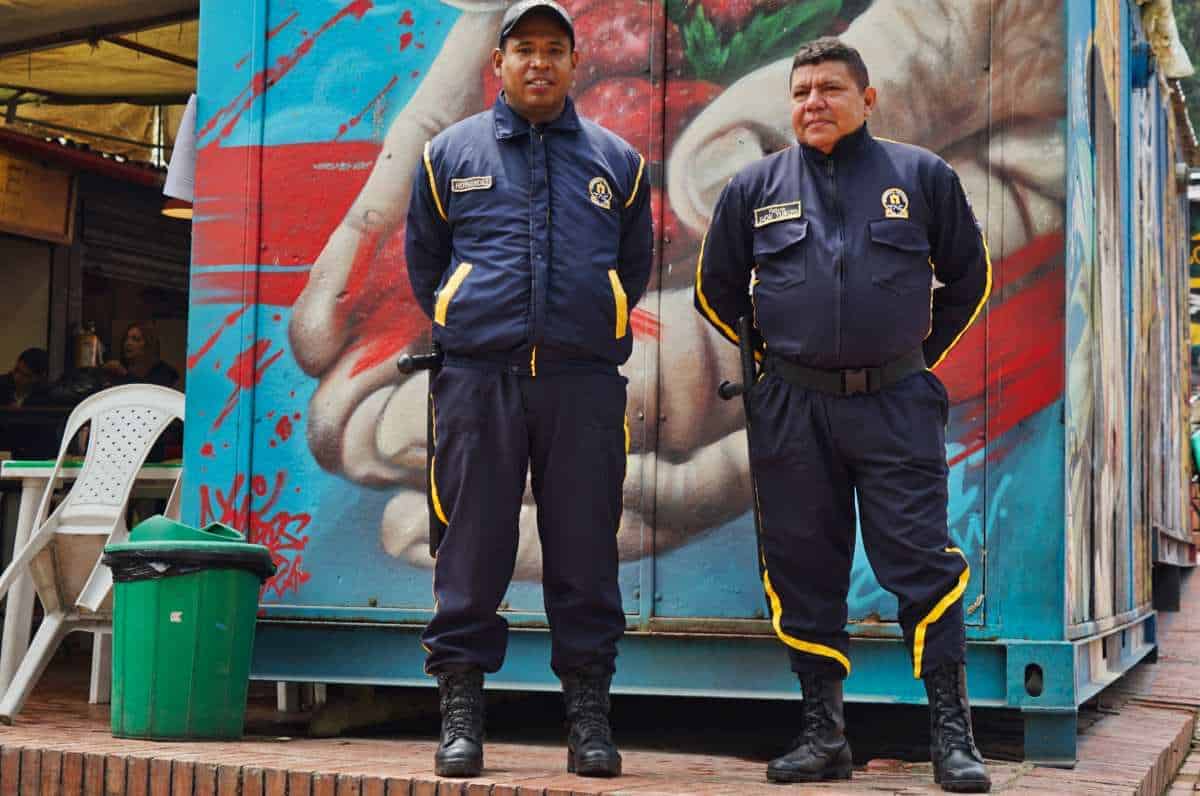 Zwei Polizisten in Bogota stehen vor einem Graffiti
