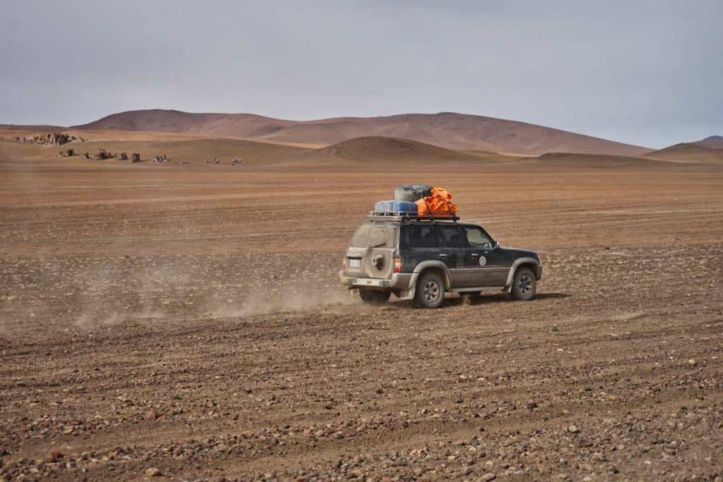 Jeep fährt durch die Wüste in den Anden von Bolivien